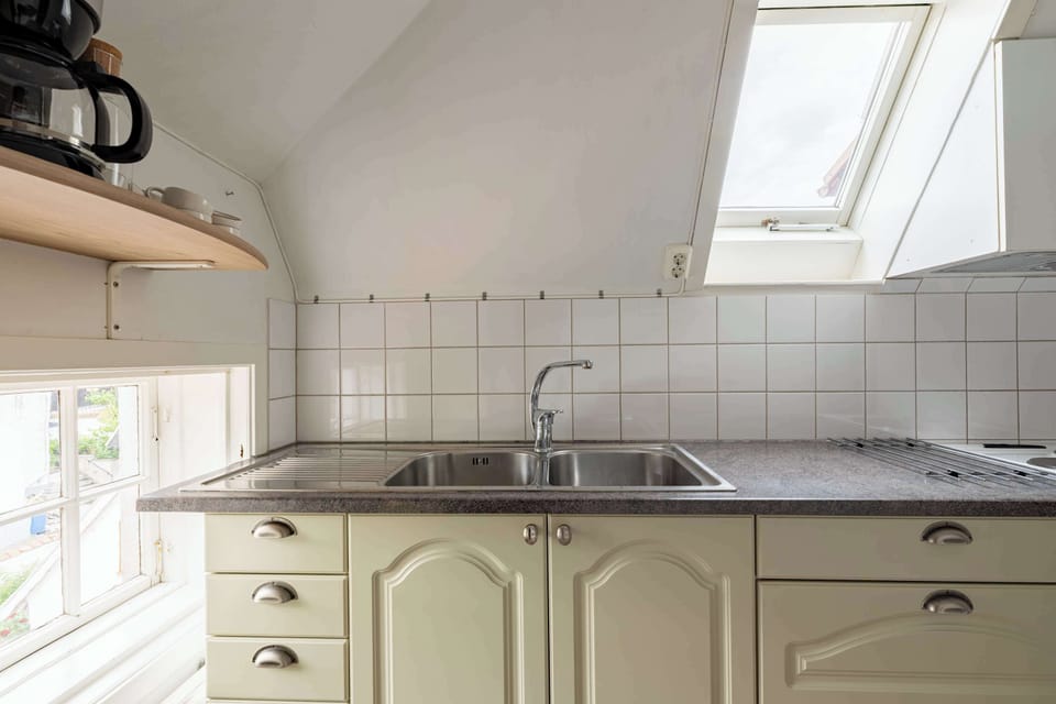 Fully equipped kitchen with all essentials you will need for a home cooked meal. There is a stove, oven, fridge, freezer, coffee maker and water boiler, and essentials. A small seating area in the kitchen for 2 guests.