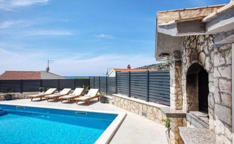 Outdoor pool, an infinity pool, pool umbrellas, sun loungers