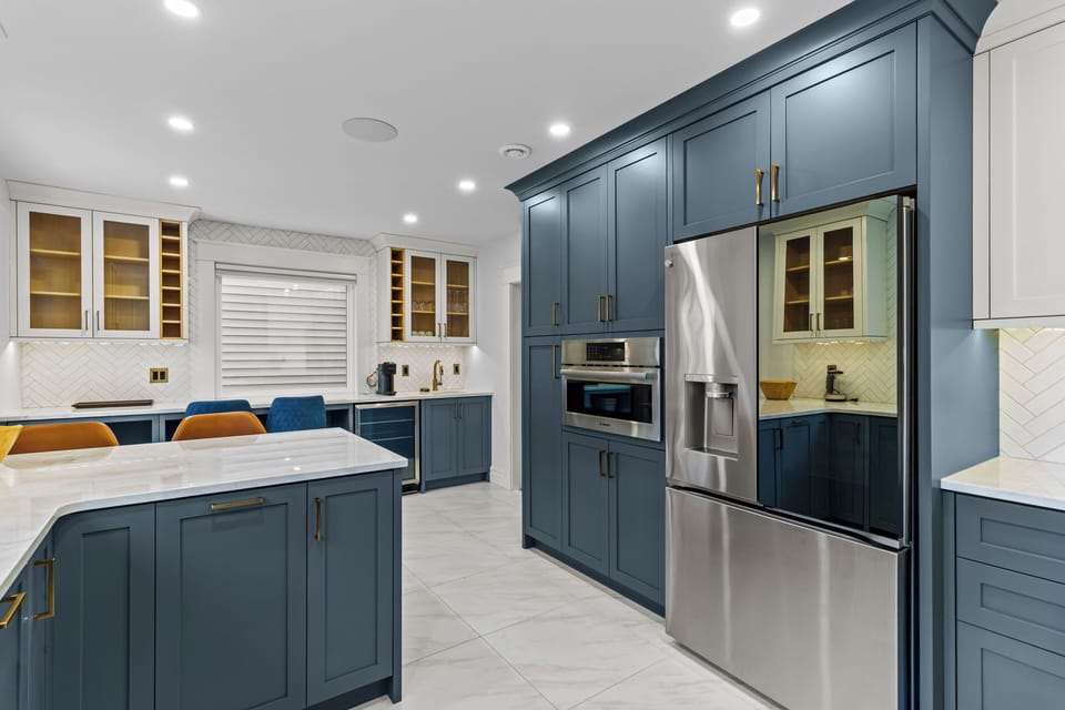 This chef's kitchen is fully equipped with double ovens, a large french-door fridge, and incredible storage space.