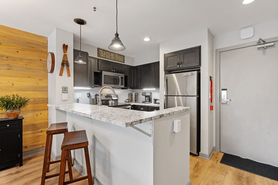 Your modern kitchen features granite countertops, stainless appliances, and a bright breakfast bar—perfect for whipping up morning coffee or evening cocktails in style.