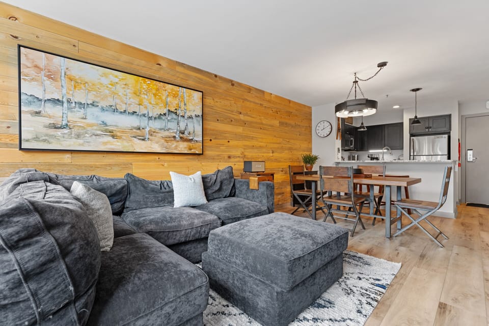 Settle into your inviting living area, where warm wood accents and modern comfort meet. The open layout flows seamlessly into a fully equipped kitchen and dining space—perfect for relaxing evenings together.