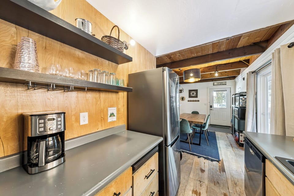Your fully-equipped kitchen awaits with modern appliances, rustic wood beams, and thoughtful storage—perfect for preparing meals in this charming space.