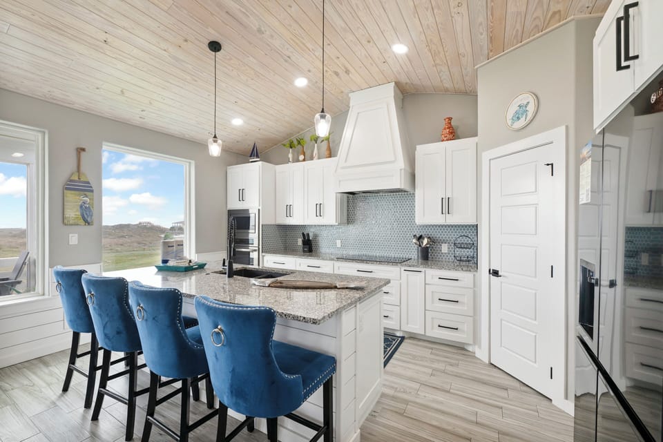 Your gourmet kitchen awaits with granite countertops, stainless appliances, and stylish blue bar seating for memorable meal prep.