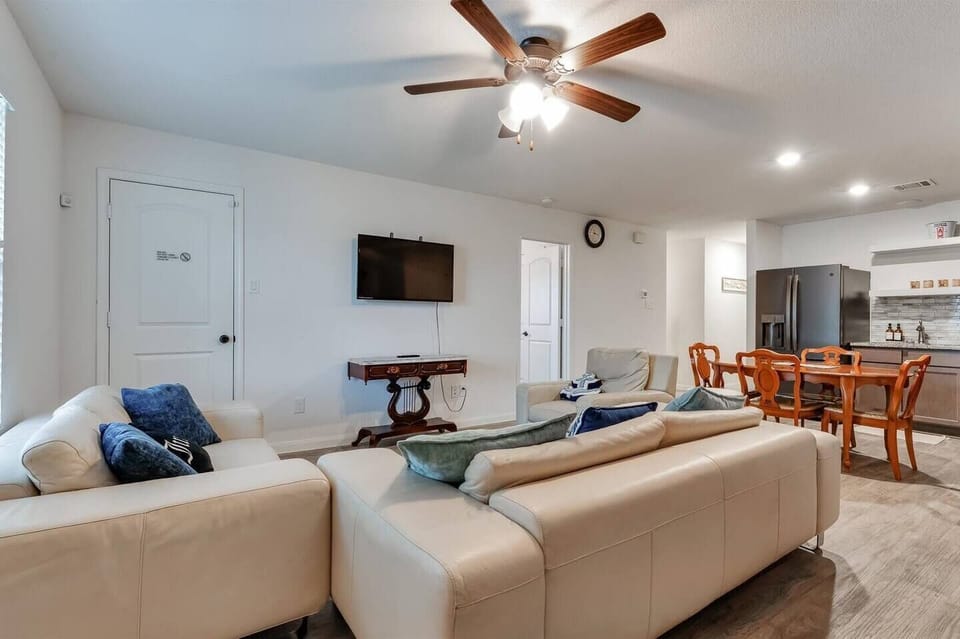 Unwind in this bright living room with plush leather sofas and fiber optic internet—perfect for streaming after boating on Lake Conroe. Features a Smart TV, stylish seating, and easy dining access. Complimentary parking included.