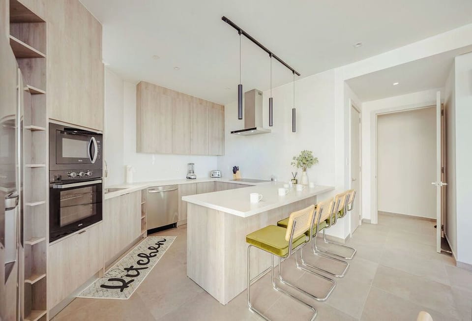 A bright, modern kitchen with sleek cabinetry and an inviting breakfast bar. You'll love preparing meals with stainless steel appliances and ample counter space for all your culinary adventures.