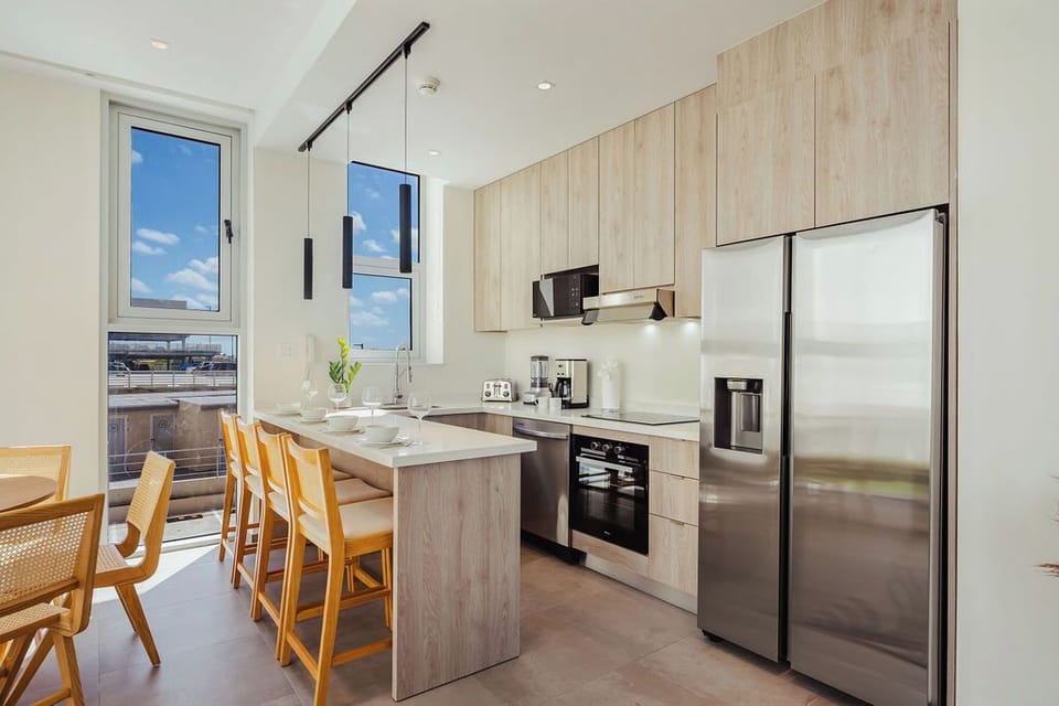 Bright, modern kitchen where you'll find everything you need—stainless appliances, spacious counters, and natural light pouring through tall windows. Perfect for preparing meals or sharing coffee with loved ones.