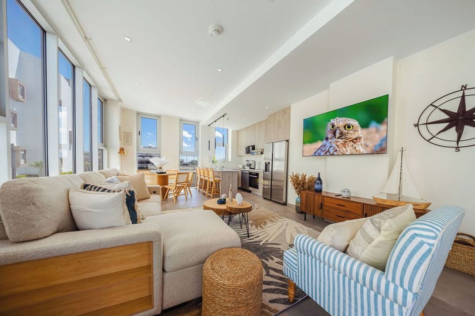 Bright, open-plan living space with soaring ceilings and coastal accents invites you to unwind in style and comfort.