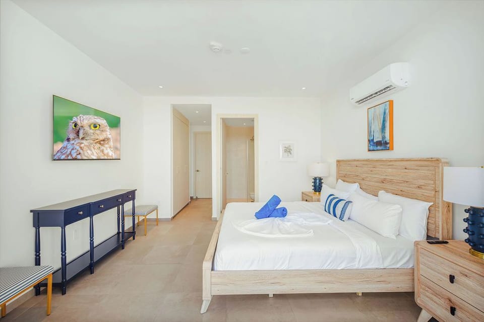Sink into crisp linens and unwind in your airy bedroom, where modern comfort meets calming coastal-inspired decor. Your perfect retreat awaits.