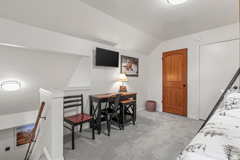 Cozy upstairs retreat with workspace, TV, and rustic charm—your perfect mountain hideaway for work or relaxation.