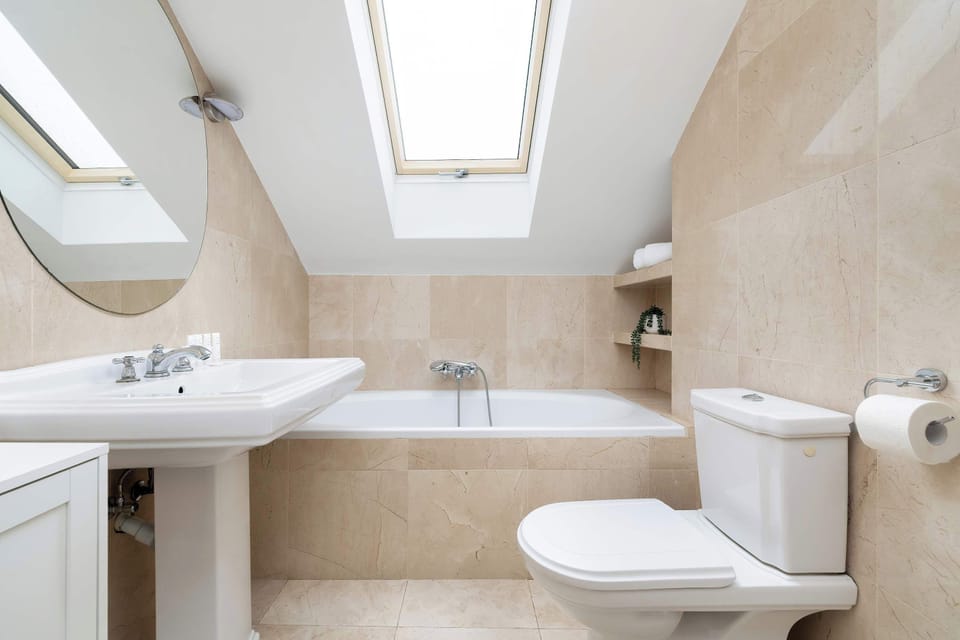 Bright bathroom with bathtub and skylight.