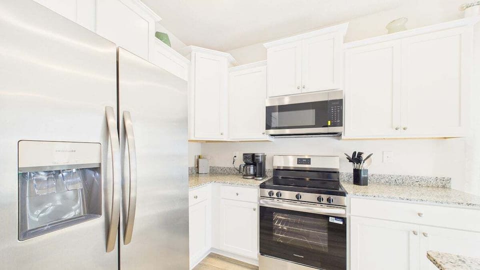 Cook your favorite meals in this bright, fully-equipped kitchen with modern stainless appliances and granite countertops.