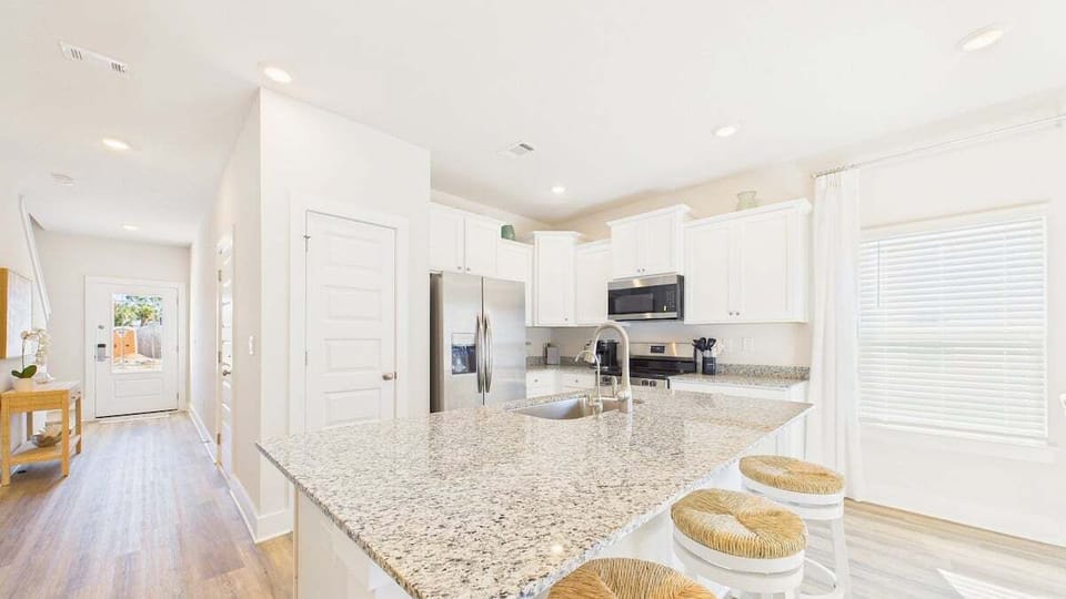 Your bright kitchen features granite counters, stainless appliances, and a breakfast bar perfect for morning coffee.