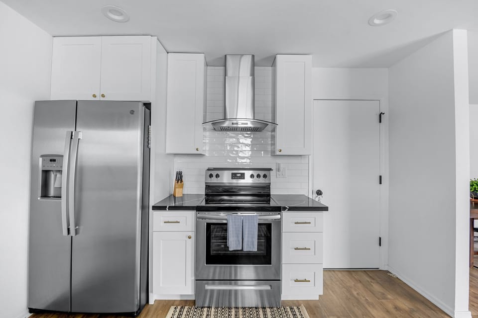 Fully equipped kitchen with a large refrigerator, stove, and all cooking essentials.