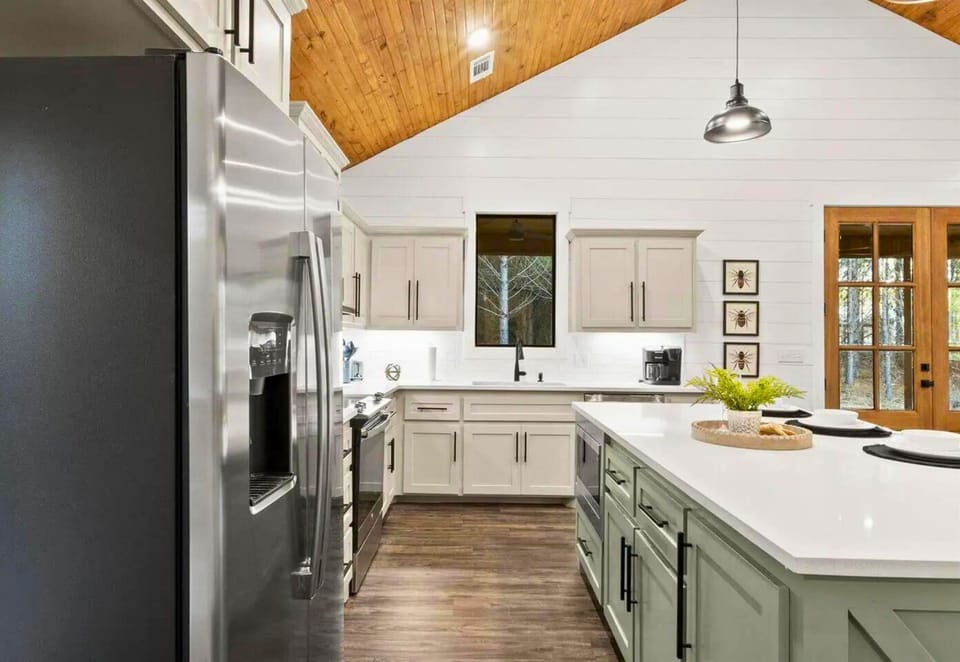 Your modern kitchen features stainless steel appliances, pristine quartz countertops, and warm wood ceilings that create the perfect space for cooking memorable meals.