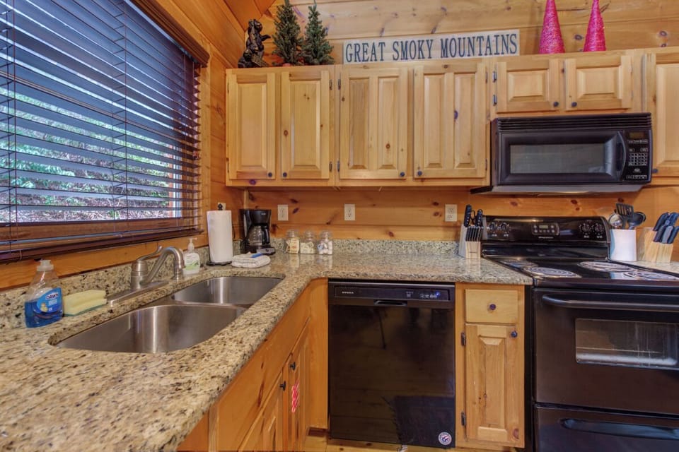Your fully-equipped kitchen awaits with granite counters, stainless appliances, and charming Great Smoky Mountains décor for memorable meal prep.