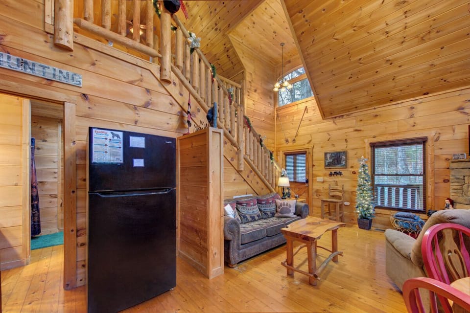 Cozy up in this rustic living space where warm wood surrounds you and soaring ceilings create an inviting atmosphere for relaxation.