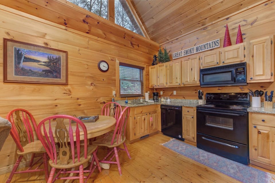 Your rustic cabin kitchen features warm wood throughout, full appliances, and cozy dining for mountain memories.