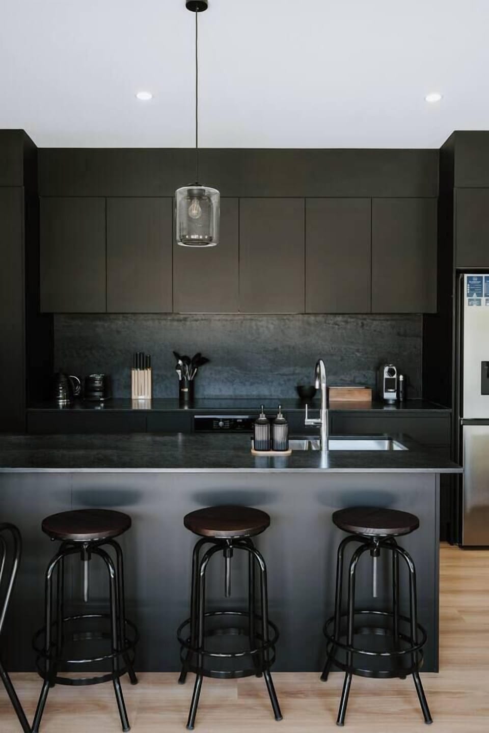 Sleek, matte-black cabinetry and clean lines frame a well-designed kitchen that makes everyday cooking feel effortless.