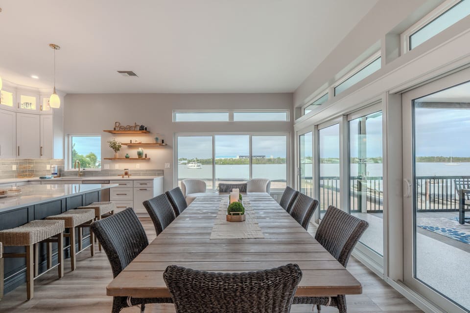 Gather around your spacious dining table while enjoying stunning water views through floor-to-ceiling windows that flood this open-concept space with natural light.