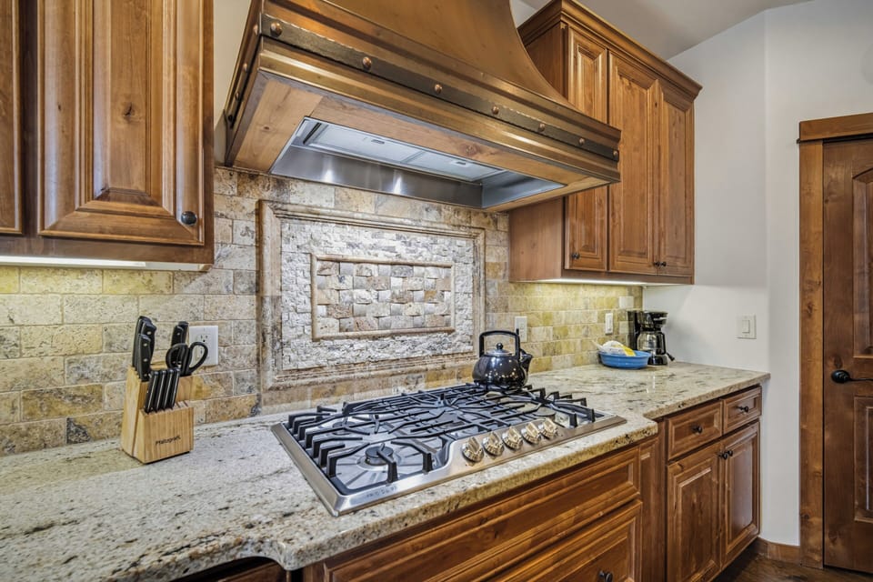 Your gourmet kitchen features granite countertops, gas cooking, and rustic stone backsplash for memorable meal preparation.