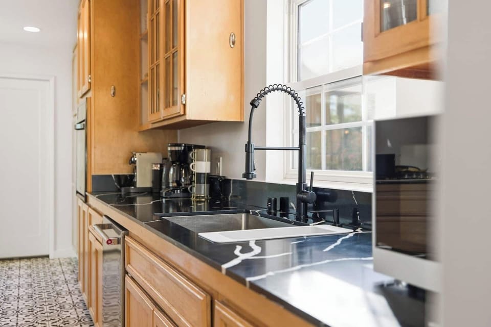 Big kitchen sink. Featuring our coffee maker, mugs, and glasses that are provided.