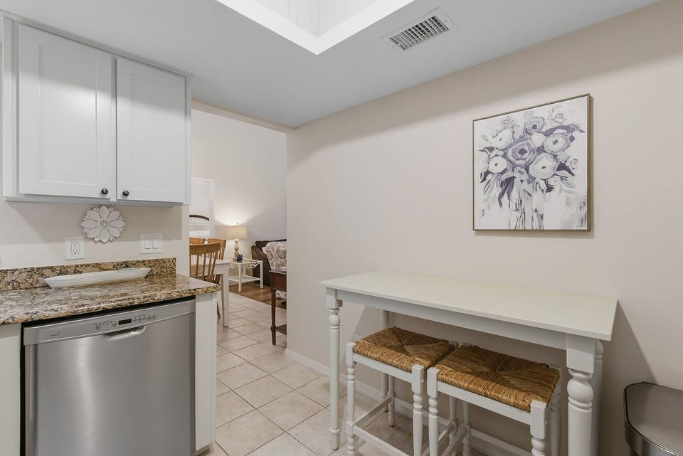 This inviting beach stay features a bright kitchen corner with granite counters and a charming breakfast nook. Perfect for morning coffee before the shore, this comfortable vacation rental blends coastal style with everyday convenience.