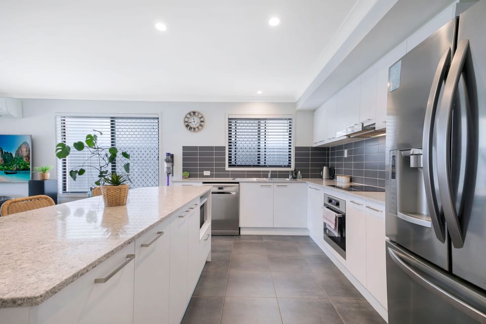 Modern appliances, including an oven, dishwasher, microwave, and full-size fridge, paired with generous bench space, make everything from quick breakfasts to home-cooked dinners feel easy.