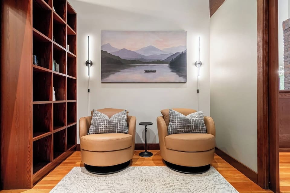 Main floor office space with seating, bookshelves, and a dedicated workstation.