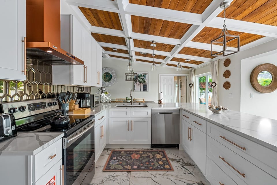 Impeccably designed Kitchen with stainless appliances, mirrored back splash, marble countertops and designer lighting