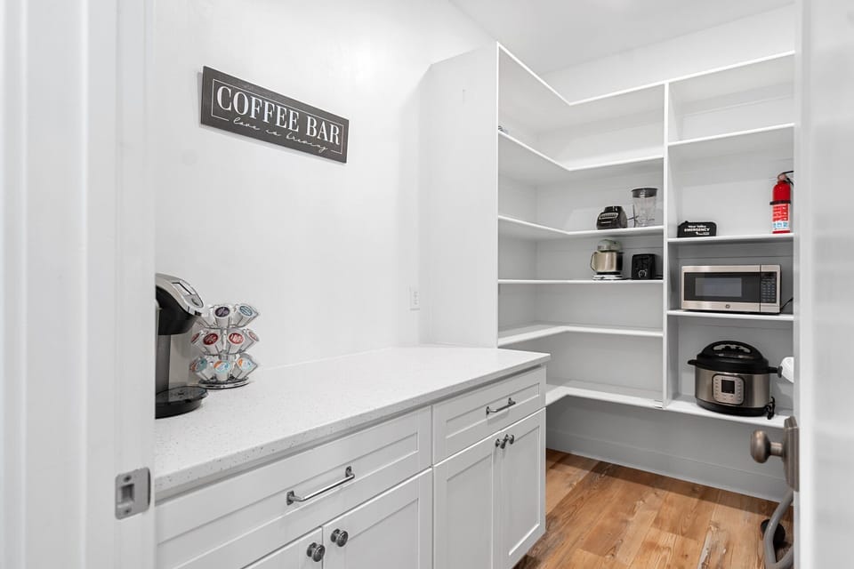 Butler's pantry with coffee bar, quartz countertops, and organized shelving for kitchen essentials.
