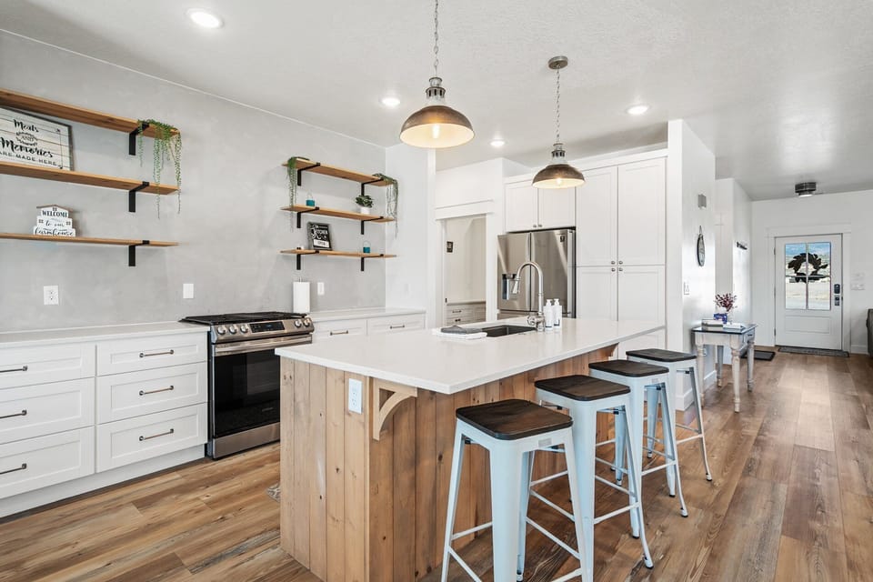 Contemporary kitchen with quartz countertops, stainless appliances, and island seating for four.
