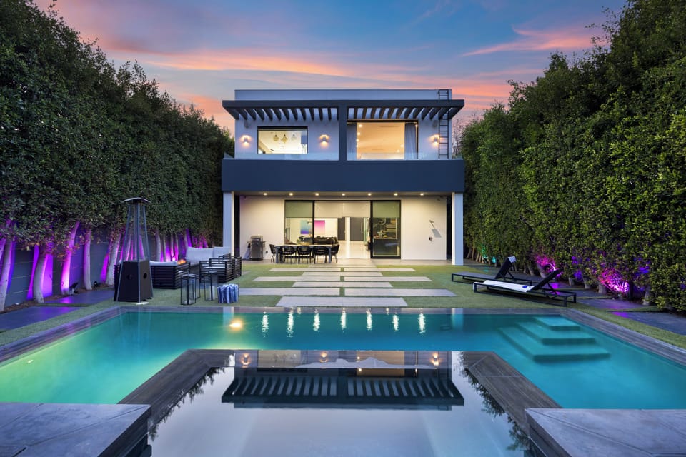Sleek modern oasis with a private pool, lush hedged yard, and seamless indoor-outdoor living.