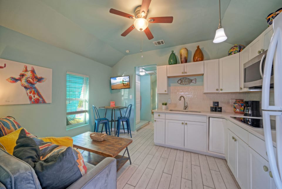 Bright, cheerful living space with coastal décor, a cozy sofa, dining nook, and a fully equipped kitchenette.