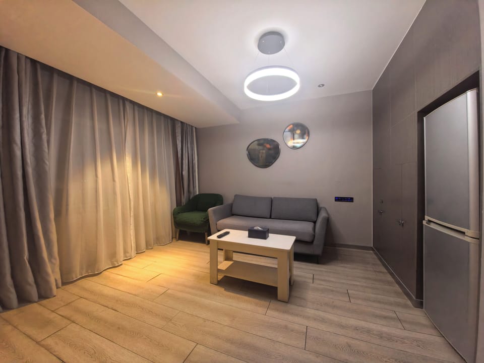 Luxury Studio Suite | Living area | 120-cm LCD TV with cable channels, smart speakers, computer monitors