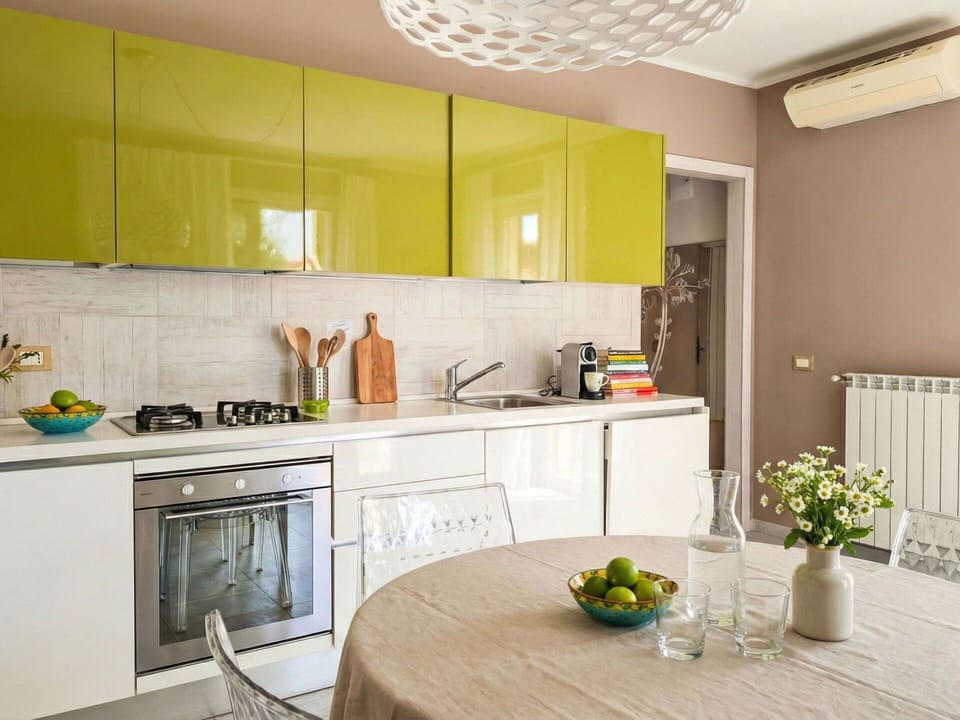 Furniture, Kitchen, Interior Design, Countertop, Kitchen Appliance, Cabinetry, Wall, Flooring, Major Appliance, Yellow