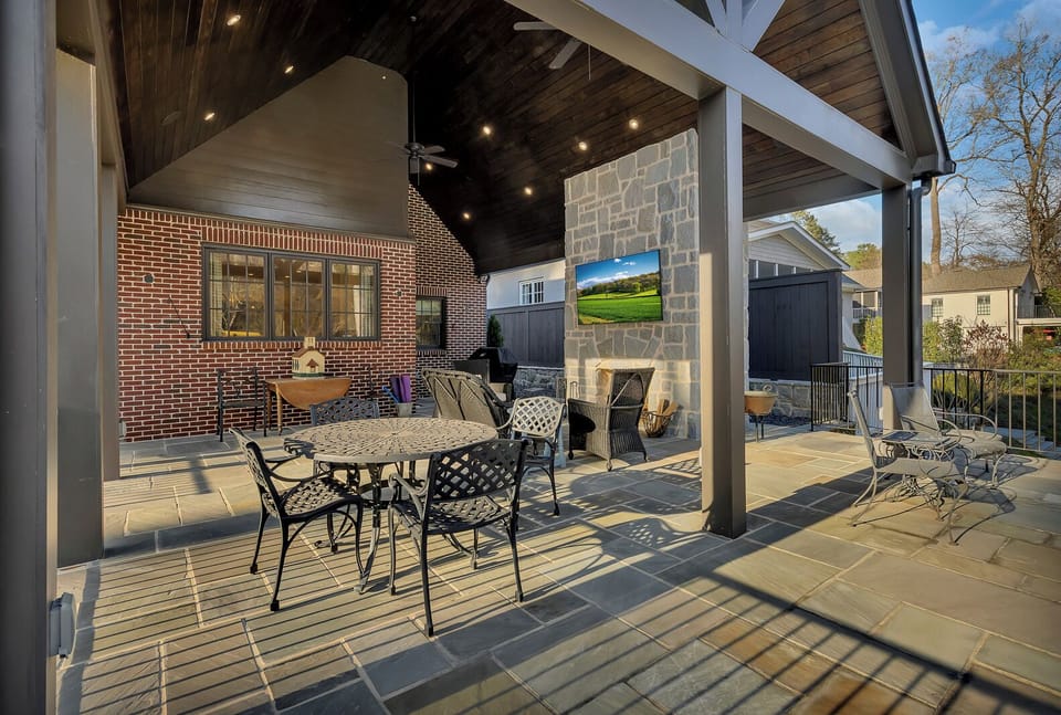 Covered outdoor patio w/ dining table, fireplace & TV for relaxed evenings outside