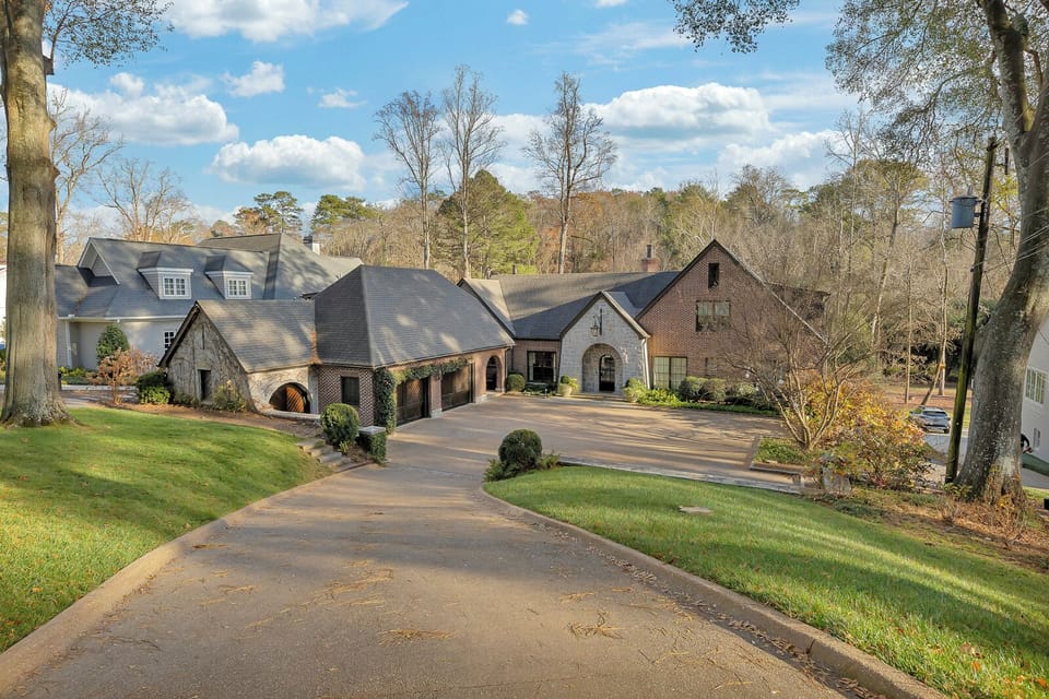 Expansive front exterior w/ sweeping driveway & landscaped surroundings