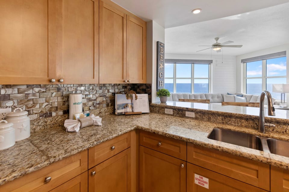 Your fully equipped kitchen features granite counters and stunning ocean views, perfect for preparing meals while watching waves.