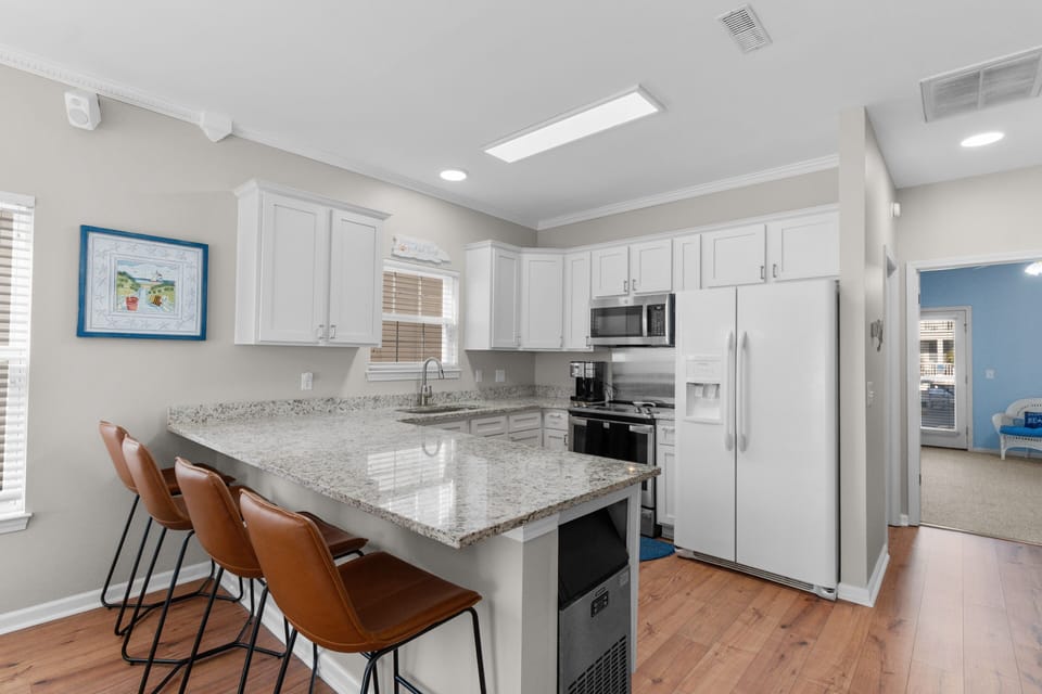 Your fully equipped kitchen features granite countertops, modern appliances, and a breakfast bar perfect for morning coffee or evening conversations.