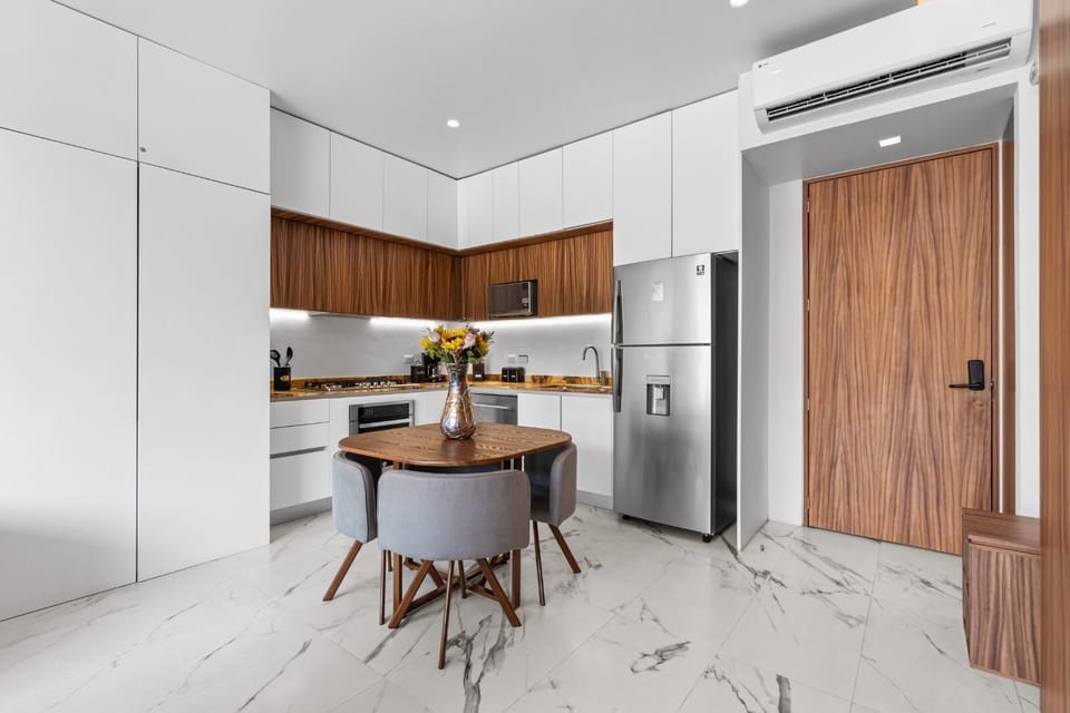 Your sleek kitchen awaits with modern appliances, warm wood accents, and a cozy dining nook perfect for morning coffee or intimate meals.