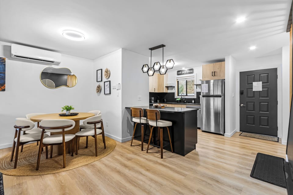 Open-concept kitchen and dining room layout! Features a 6-person dining table, black granite kitchen island with breakfast bar stools, hardwood-style floors, and a private main entry door. Perfect family-friendly Camelback Resort basecamp.