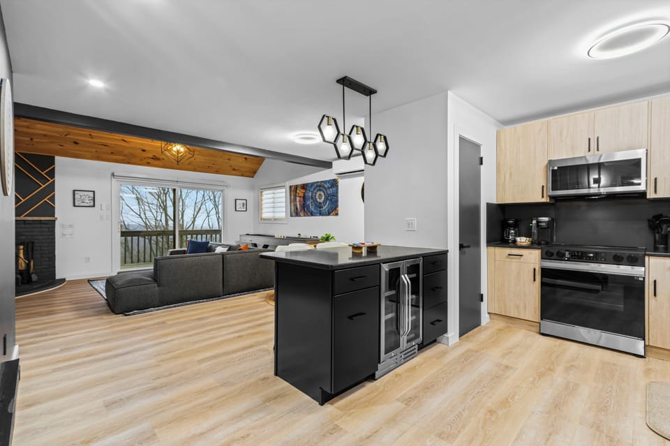 Open-concept townhouse main floor! Combines a sleek kitchen island with wine refrigerator, stainless steel appliances, a cozy sectional sofa lounge, and an indoor fireplace. Perfect family or group basecamp at Camelback Mountain.