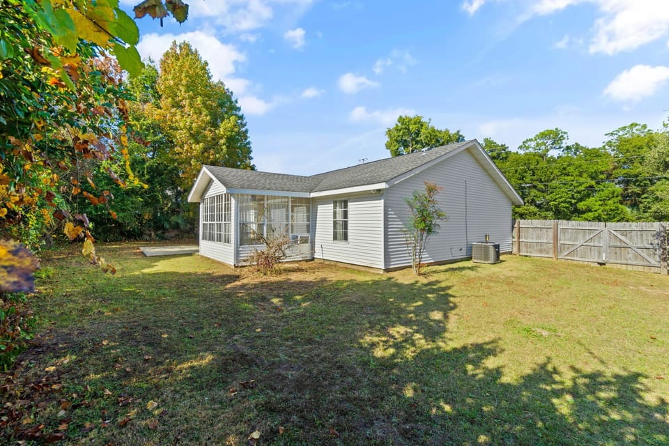 Enjoy privacy and open space in this large backyard with a sunny patio and enclosed sunroom access. Whether you're soaking up the sun or planning a family cookout, this yard is ready for it all.