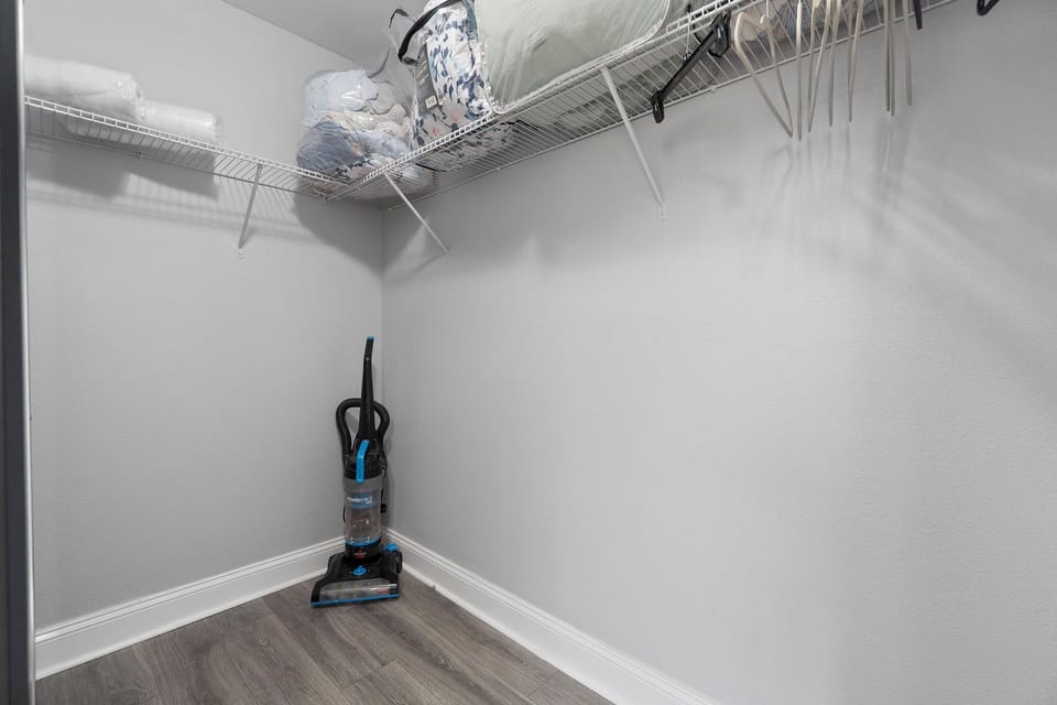 Outfitted with ample shelving, extra linens, hangers, and a vacuum cleaner, this area provides all the storage and supplies needed for a comfortable extended stay.