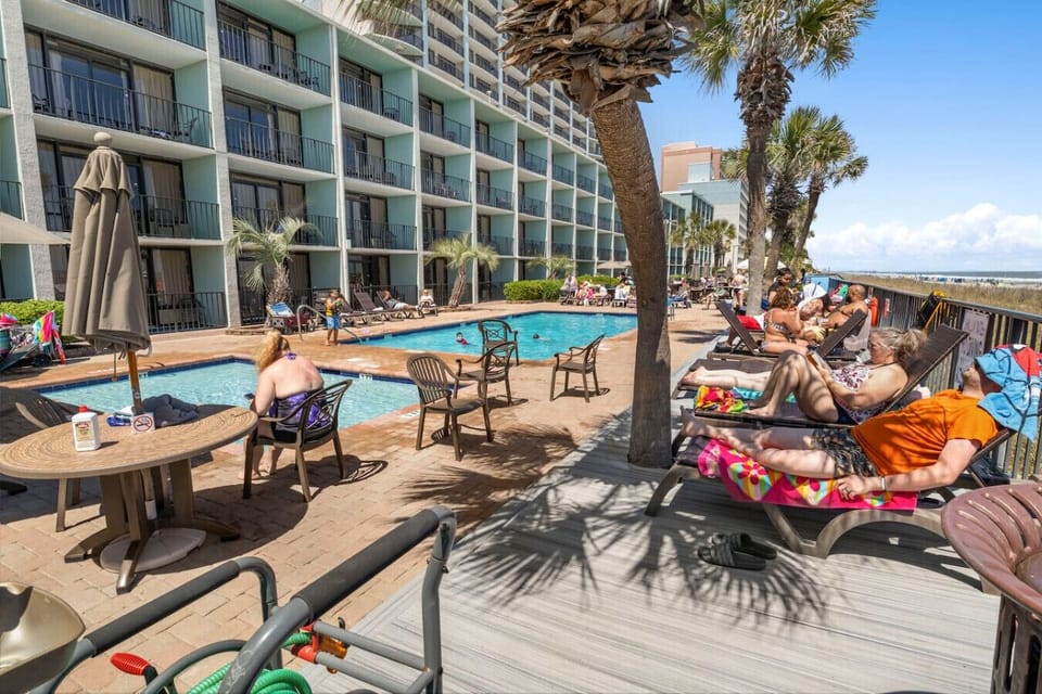 Oceanfront outdoor pool with a poolside beach bar, relaxing hot tub, and direct beach access. Enjoy refreshing swims, drinks by the water, and effortless walks to the sand and shoreline.