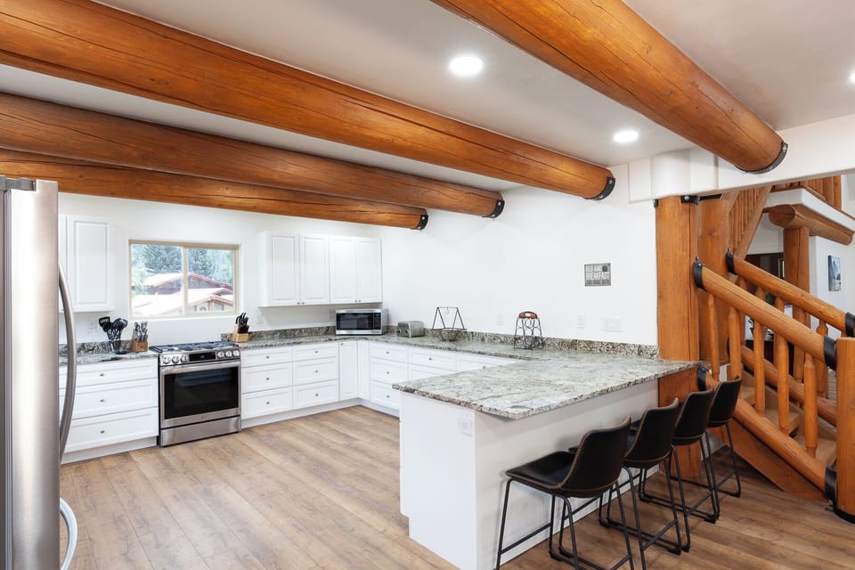 Gather around this spacious kitchen island, where rustic beams overhead meet modern convenience. Whip up your favorite meals with granite countertops, stainless appliances, and all the space you need to cook and connect.
