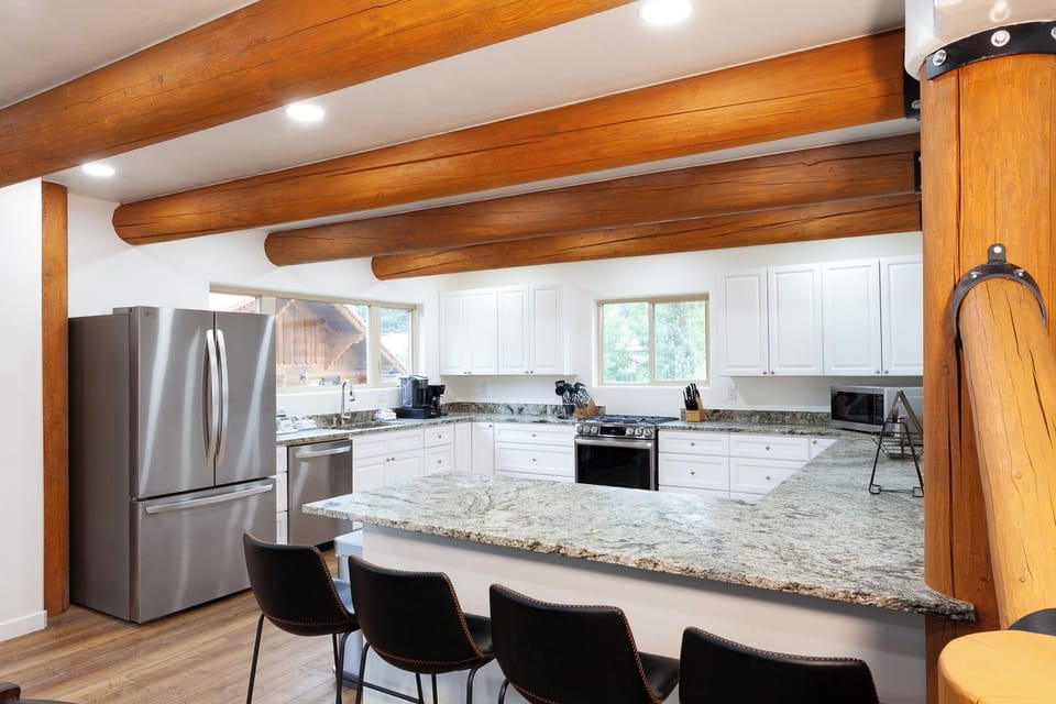 Picture yourself cooking in this spacious kitchen, where warm wooden beams and gleaming granite counters invite you to gather and create memorable meals with family and friends.