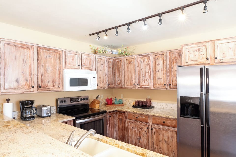Your fully equipped kitchen features rustic wood cabinetry, granite countertops, and stainless steel appliances—perfect for preparing meals together during your stay.