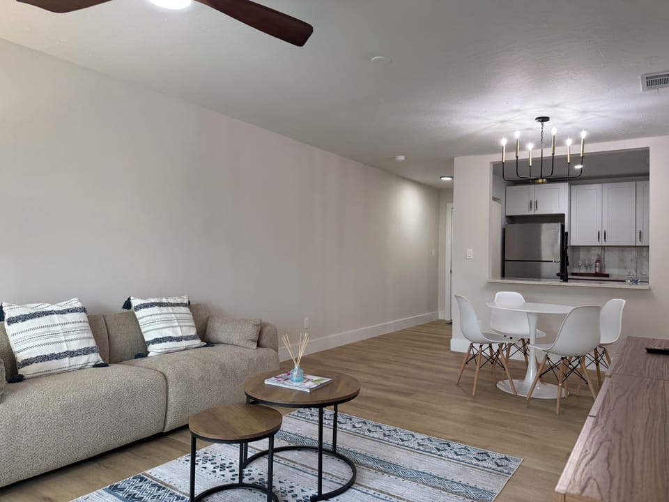 Relax in your modern living space featuring plush seating, elegant hardwood floors, and a fully equipped kitchen perfect for memorable meals.
