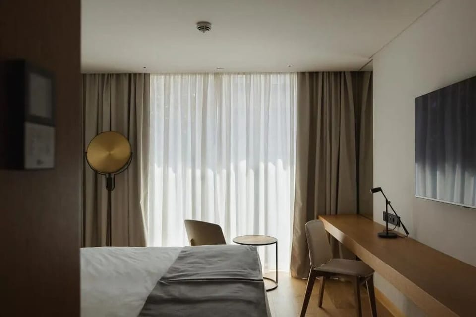 Settle into a cozy corner with workspace and soft curtains.